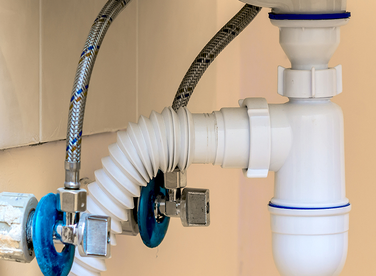 photo of waste and feed pipes under a bathroom vanity
